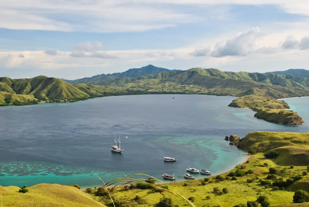 Traditional Indonesian phinisi liveaboard yacht on turquoise water in Komodo and Raja Ampat